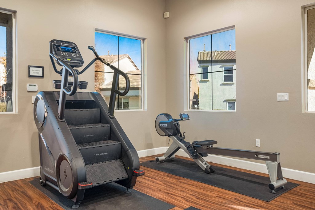 A home gym with a treadmill, elliptical trainer and a stair climber.